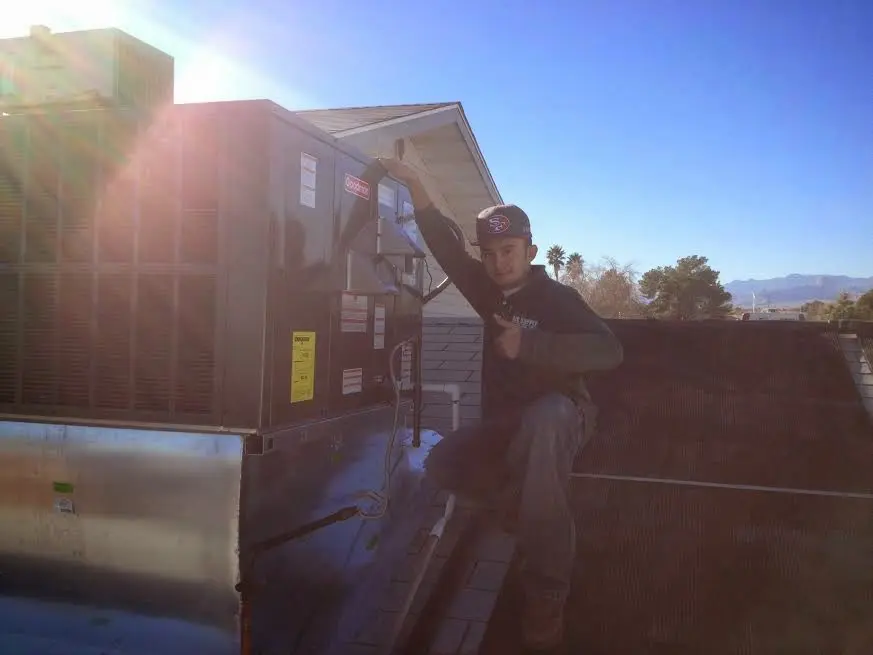 HVAC technician performing Air Duct Cleaning on a rooftop unit in Lanett